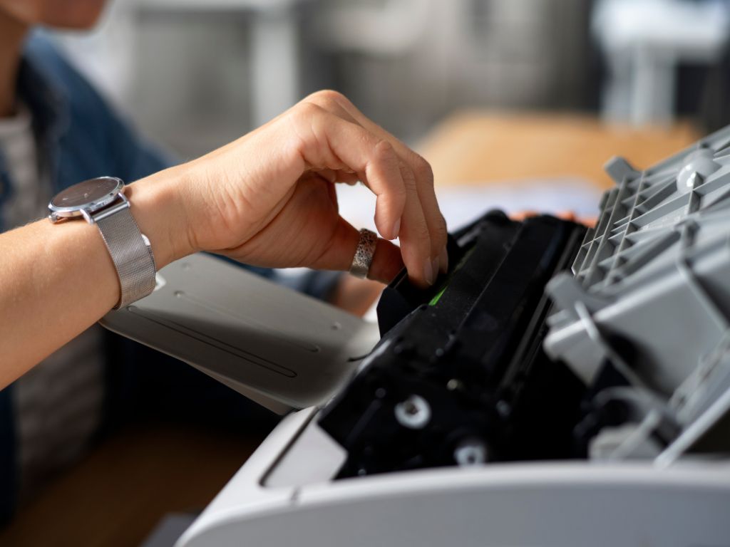 Driver and firmware recovery on a laptop next to a printer